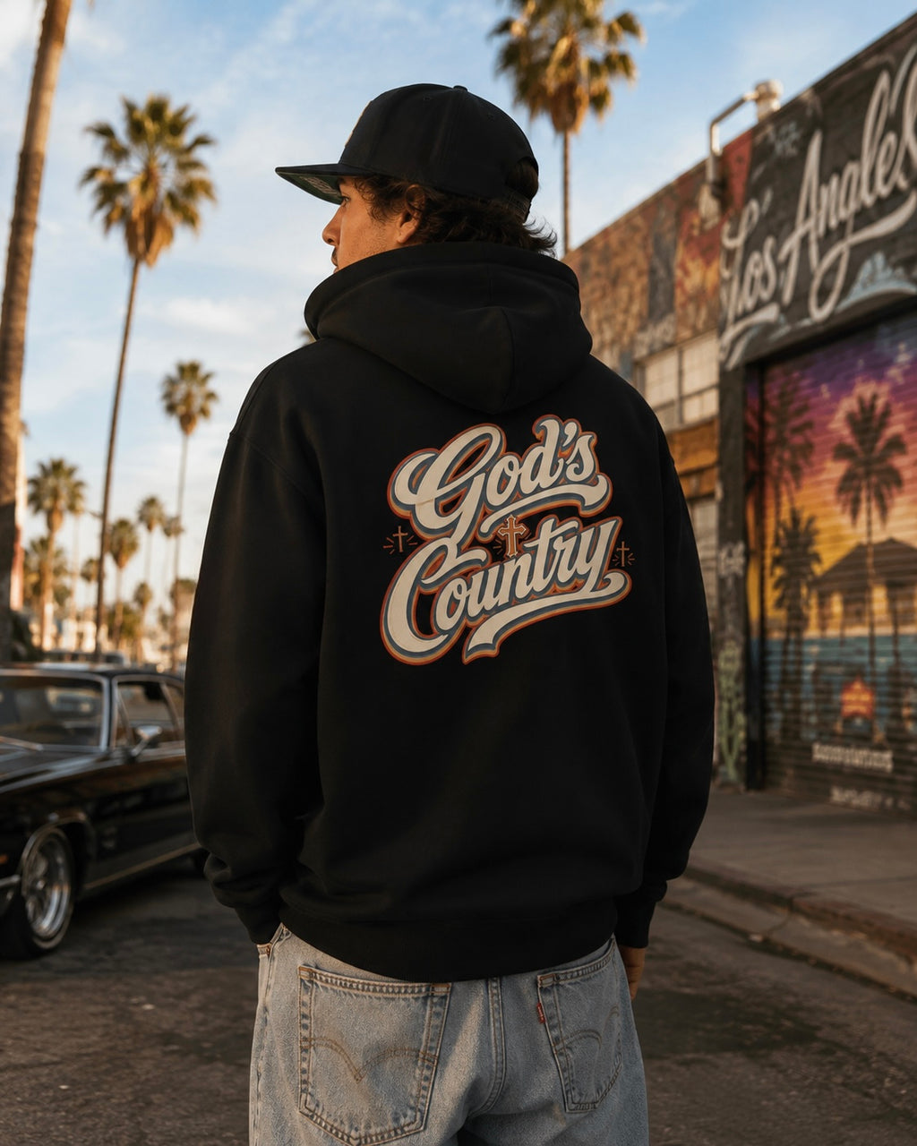 Black hoodie worn outdoors, with large 'God's Country' back graphic and hood