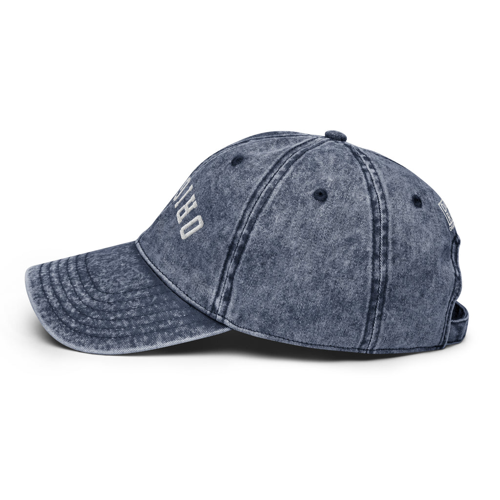 Vintage baseball cap in dark blue denim look with stitched panels and small logo print.