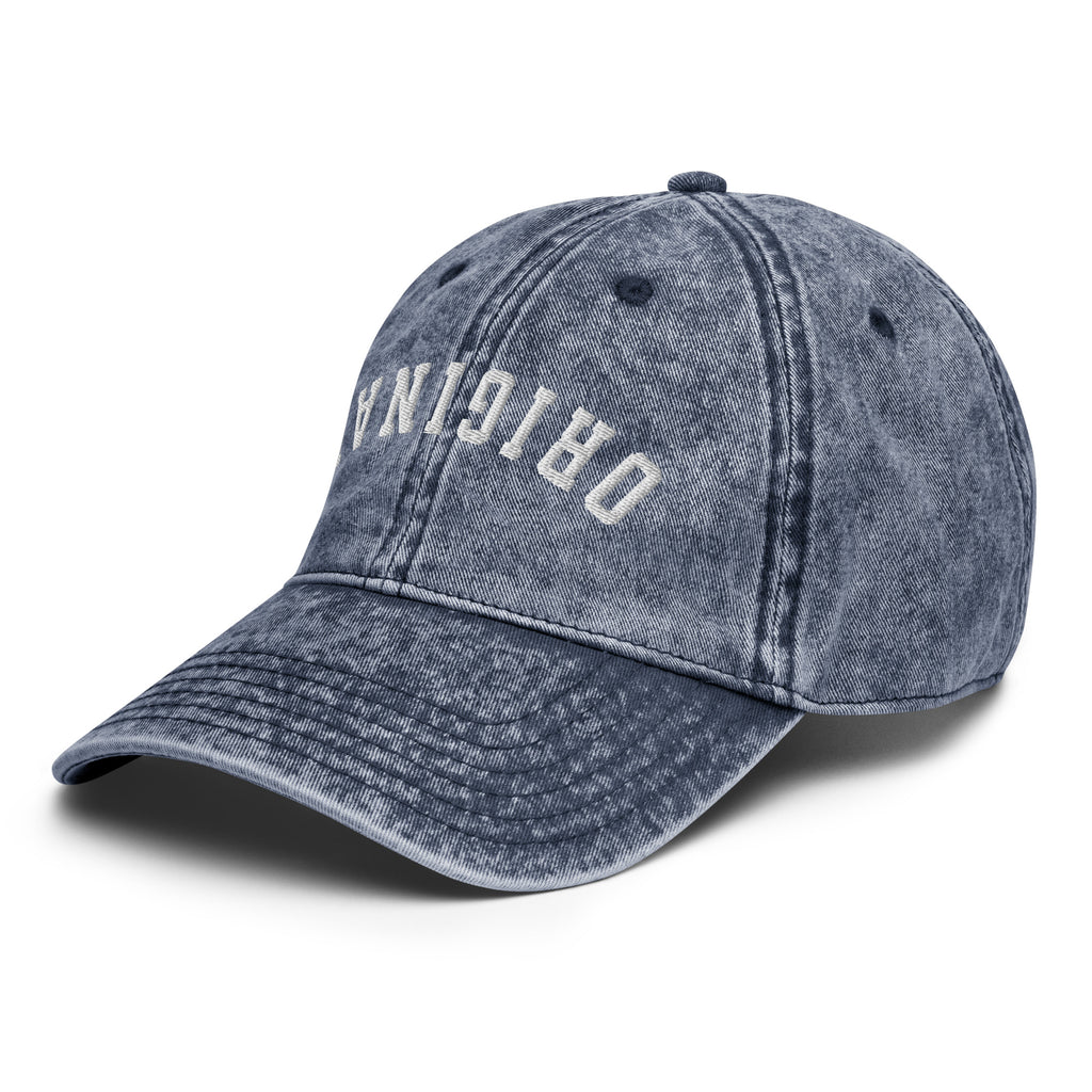 Vintage baseball cap in dark blue denim look with front logo text and curved brim.