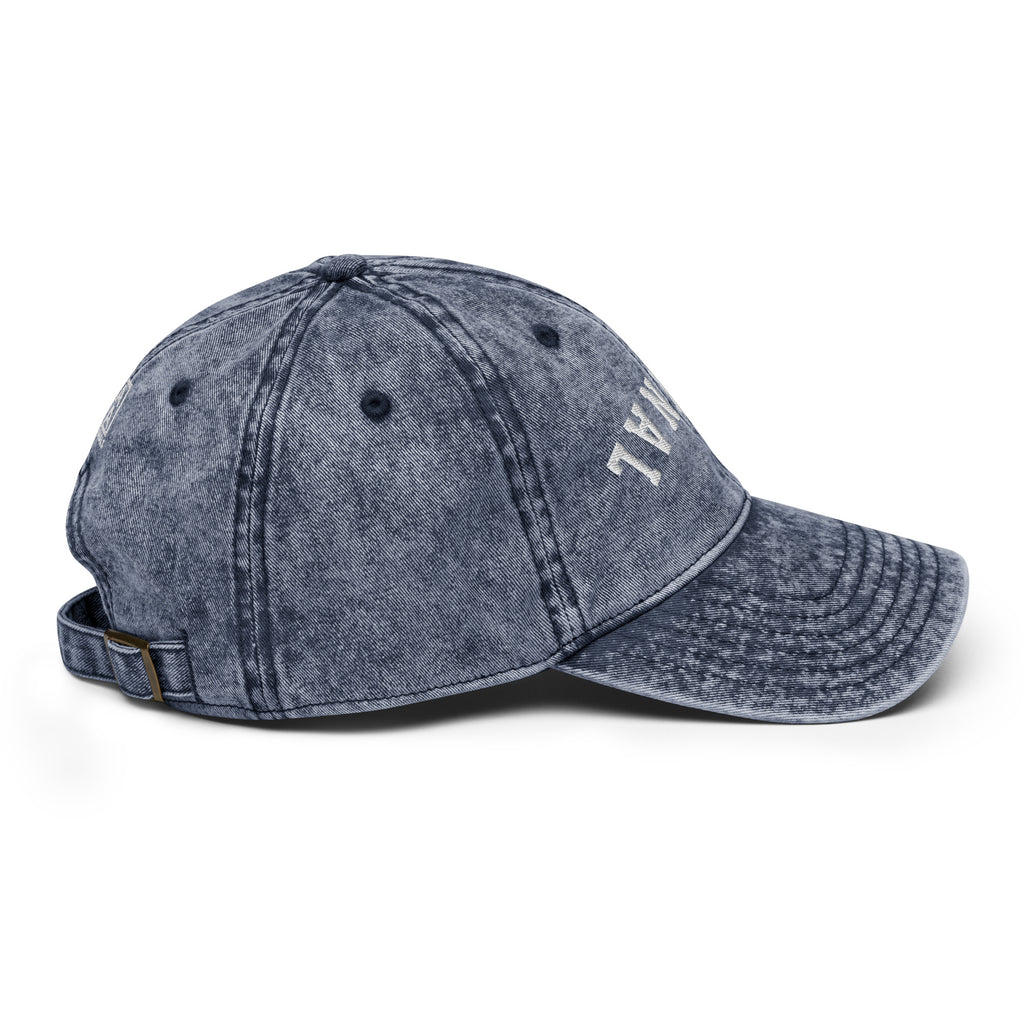 Vintage baseball cap in dark blue denim look with side logo and structured stitched panels.