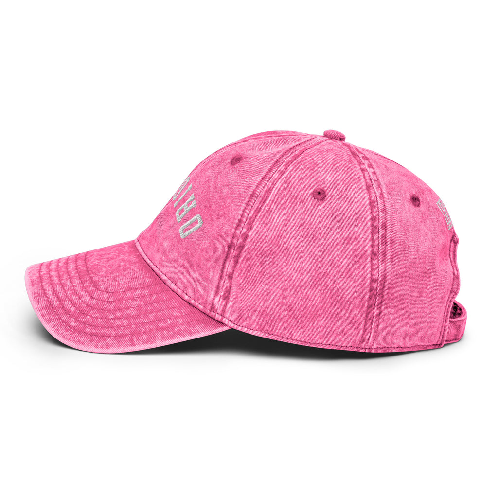 Pink vintage baseball cap with distressed side lettering and adjustable back strap.